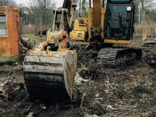 Heavy equipment clearing brush and trees from a wooded building lot in Connecticut