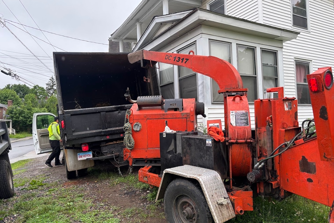 Wood chipper and dump truck loaded with tree debris at a job site